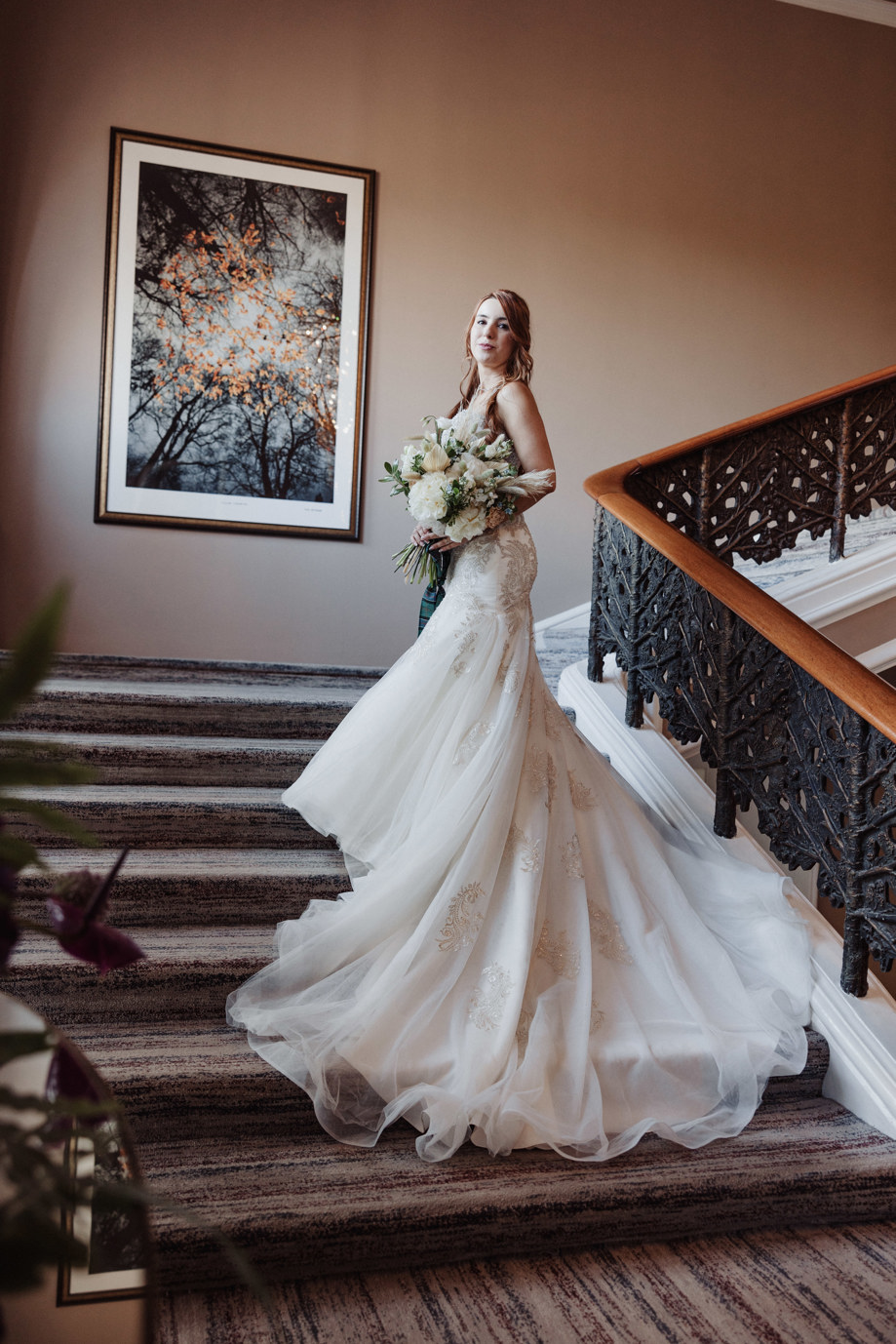 Bride poses on stairs at Dean Banks at The Pompadour